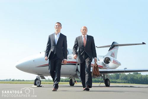 Two business executives walking away from corporate jet at airfield